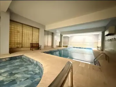 a large indoor swimming pool with a large tub at Maison LINA in Marrakech