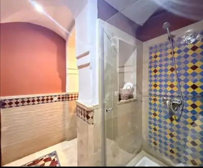 a shower with a glass door in a bathroom at Maison LINA in Marrakech