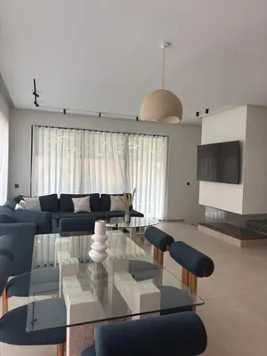 a living room with a glass table and a blue couch at Villa 5 suites piscine privée in Marrakech