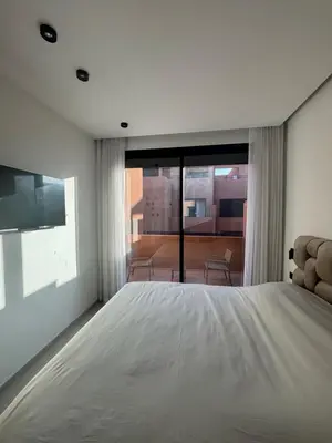 a bedroom with a large bed and a large window at Villa 5 suites piscine privée in Marrakech