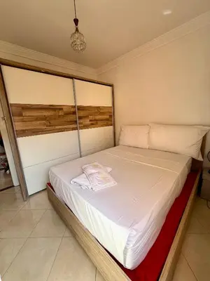 a bedroom with a large bed with a white bedspread at Layla Apartment in Marrakech