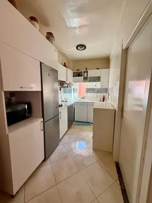 a kitchen with white cabinets and a tile floor at Layla Apartment in Marrakech