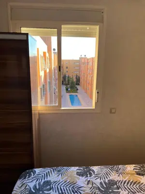 a bedroom with a window with a view of a courtyard at Appartement bien équipé avec piscine sur Marrakech in Marrakech