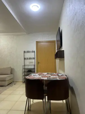 a dining room with a table and some chairs at Appartement bien équipé avec piscine sur Marrakech in Marrakech
