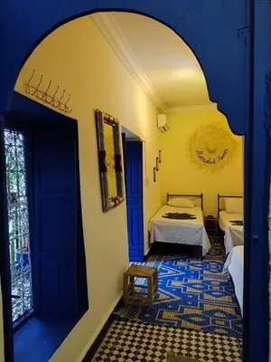 a room with a bed and a room with a window at Riad Sijane in Marrakech
