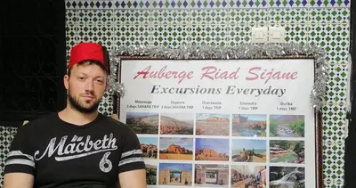 a man is sitting in front of a sign at Riad Sijane in Marrakech