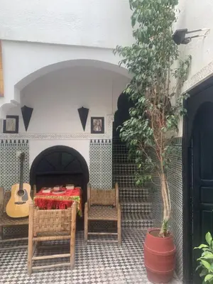a table and chairs in a courtyard with a guitar at Riad Sijane in Marrakech