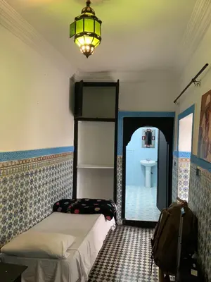 a bedroom with a bed and a lamp and a sink at Riad Sijane in Marrakech