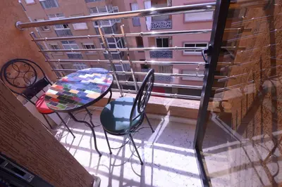 a balcony with a table and chairs on a balcony at Appartement Spacieux Idéal Séjours Longs in Marrakech