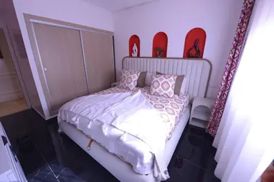 a bedroom with a bed with shoes on the wall at Appartement Spacieux Idéal Séjours Longs in Marrakech