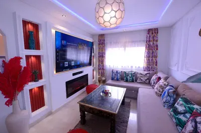 a living room with a couch and a tv at Appartement Spacieux Idéal Séjours Longs in Marrakech