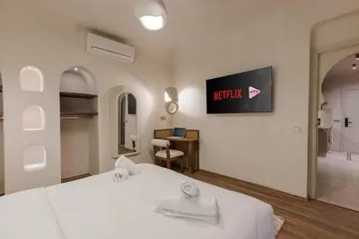 a hotel room with a bed and a tv on the wall at City Center 1 BED Apartments - Miramas - Pool and gym in Marrakech