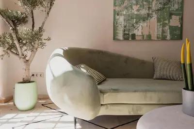 a living room with a green couch and a tree at City Center 1 BED Apartments - Miramas - Pool and gym in Marrakech