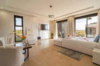 a bedroom with a large bed and a large window at Luxury Villa Hammam Piscine chauffeé sans Vis Avis in El Harkat
