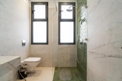 a bathroom with a toilet and a shower with windows at Luxury Villa Hammam Piscine chauffeé sans Vis Avis in El Harkat