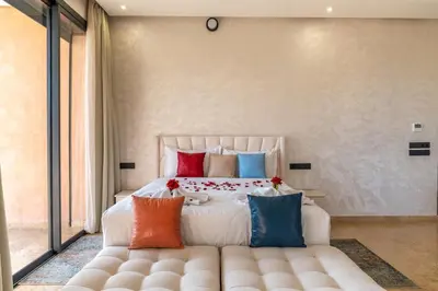 a bedroom with a large bed with colorful pillows at Luxury Villa Hammam Piscine chauffeé sans Vis Avis in El Harkat