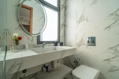 a white bathroom with a sink and a mirror at Luxury Villa Hammam Piscine chauffeé sans Vis Avis in El Harkat