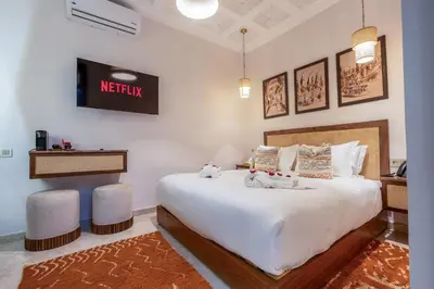 a bedroom with a large white bed with two stuffed animals on it at Riad Janate BAHIA & Spa in Marrakech