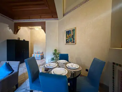 a dining room with a table and blue chairs at le pavillon de la palmeraie - Piscine et jardins in Marrakech