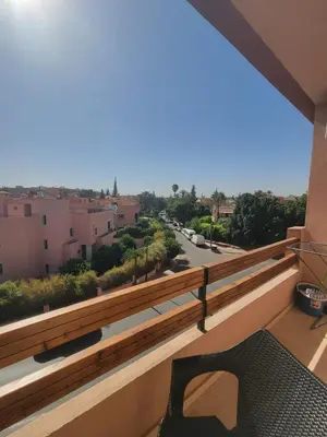 a balcony with a bench and a view of a street at Nour Prestige Appartement Moderne Piscines Résidence Sécurisée in Marrakech