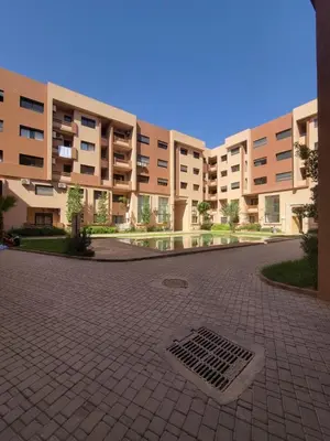 a large apartment building with a drain in the courtyard at Nour Prestige Appartement Moderne Piscines Résidence Sécurisée in Marrakech
