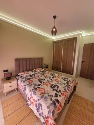 a bedroom with a bed with a colorful comforter at Nour Prestige Appartement Moderne Piscines Résidence Sécurisée in Marrakech