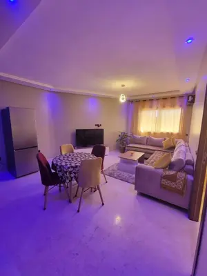 a living room with a couch and a table at Nour Prestige Appartement Moderne Piscines Résidence Sécurisée in Marrakech