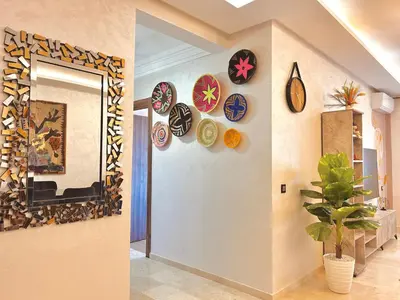 a hallway with a bunch of plates on the wall at Appartement Chic près M Avenue Piscine Balcon in Marrakech