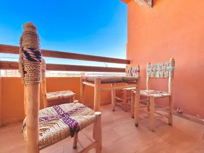 a room with two chairs and a table and a window at Appartement Chic près M Avenue Piscine Balcon in Marrakech