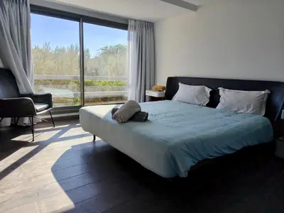 a bedroom with a large bed and a large window at Duplexe Moderne 2 suites è Oliver Palm Resort in Marrakech