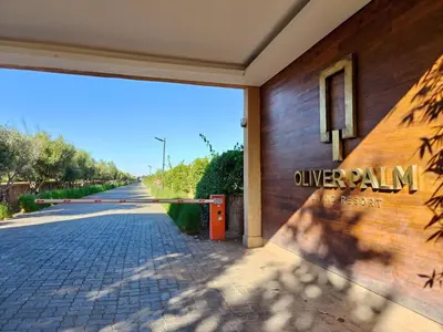 a building with a sign on the side of a street at Duplexe Moderne 2 suites è Oliver Palm Resort in Marrakech