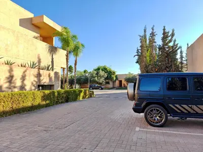 a blue jeep parked on the side of a street at Duplexe Moderne 2 suites è Oliver Palm Resort in Marrakech