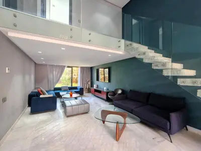 a living room with a couch and a staircase at Duplexe Moderne 2 suites è Oliver Palm Resort in Marrakech