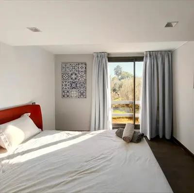 a bedroom with a bed and a large window at Duplexe Moderne 2 suites è Oliver Palm Resort in Marrakech