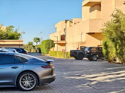 a car parked in a parking lot next to a building at Duplexe Moderne 3 suites à Oliver Palm Resort in Marrakech
