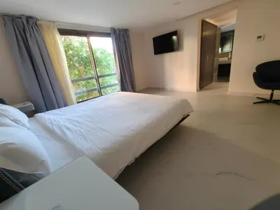a bedroom with a large bed and a window at Duplexe Moderne 3 suites à Oliver Palm Resort in Marrakech