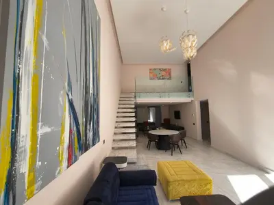 a living room with a couch and a table at Duplexe Moderne 3 suites à Oliver Palm Resort in Marrakech