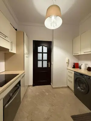a kitchen with a washer and a black door at Premium Stay in a Prestigious Residence with a Pool in Marrakech