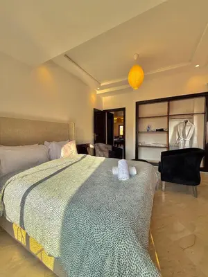 a bedroom with a bed and a room with a chair at Premium Stay in a Prestigious Residence with a Pool in Marrakech