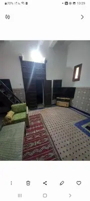 a room with a room with a rug and a room with a table and chairs at Madam Laila house in Marrakesh in Marrakech