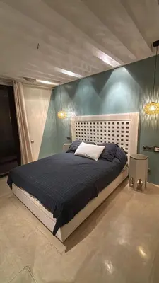 a bedroom with a large bed with a blue wall at Appartement centre Marrakech avec piscine in Marrakech