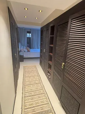 a hallway with two sets of doors and a rug at Appartement centre Marrakech avec piscine in Marrakech