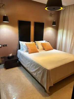 a bedroom with a large bed with orange pillows at Appartement centre Marrakech avec piscine in Marrakech
