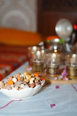 a white bowl of food on a table with jars at Riad Dar Ceramic in Marrakech