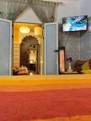 a living room with a tv on the wall at Riad Dar Ceramic in Marrakech
