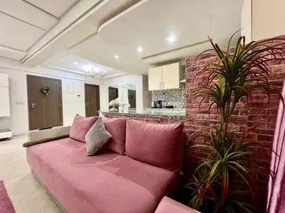 a pink couch in a living room with a brick wall at Rosa High standing apartment in Marrakech