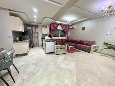 a living room with a red couch and a kitchen at Rosa High standing apartment in Marrakech