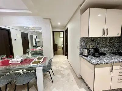 a kitchen with a table and chairs in a room at Rosa High standing apartment in Marrakech