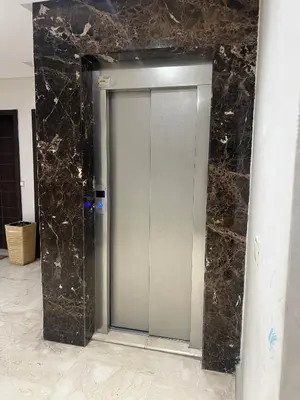 a silver elevator in a building with a marble wall at Rosa High standing apartment in Marrakech