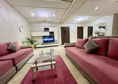 a living room with pink couches and a tv at Rosa High standing apartment in Marrakech